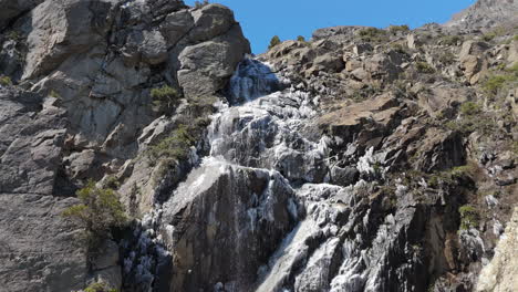 picturesque waterfall with ice in rocky mountain on route 40, san martin de los andes, patagonia, neuquén, argentina
