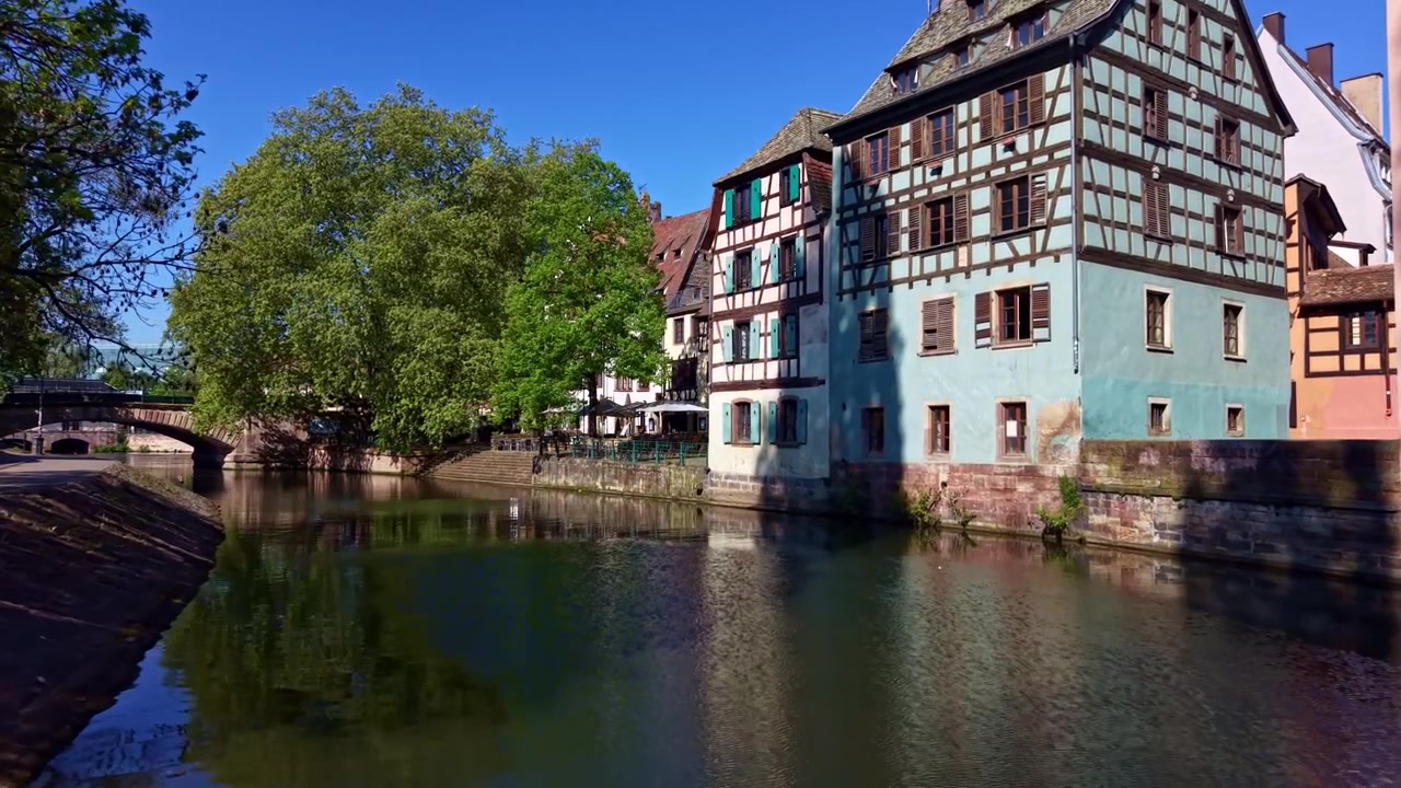 Case tradizionali colorate lungo il canale al Quai de la Petite France a Strasburgo, Francia. Volo basso di drone aereo, spazio per il testo