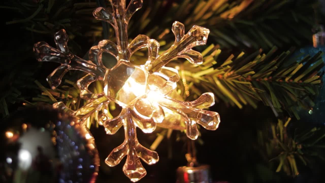 luz brillando a través de la decoración de copos de nieve de cristal en el árbol de navidad