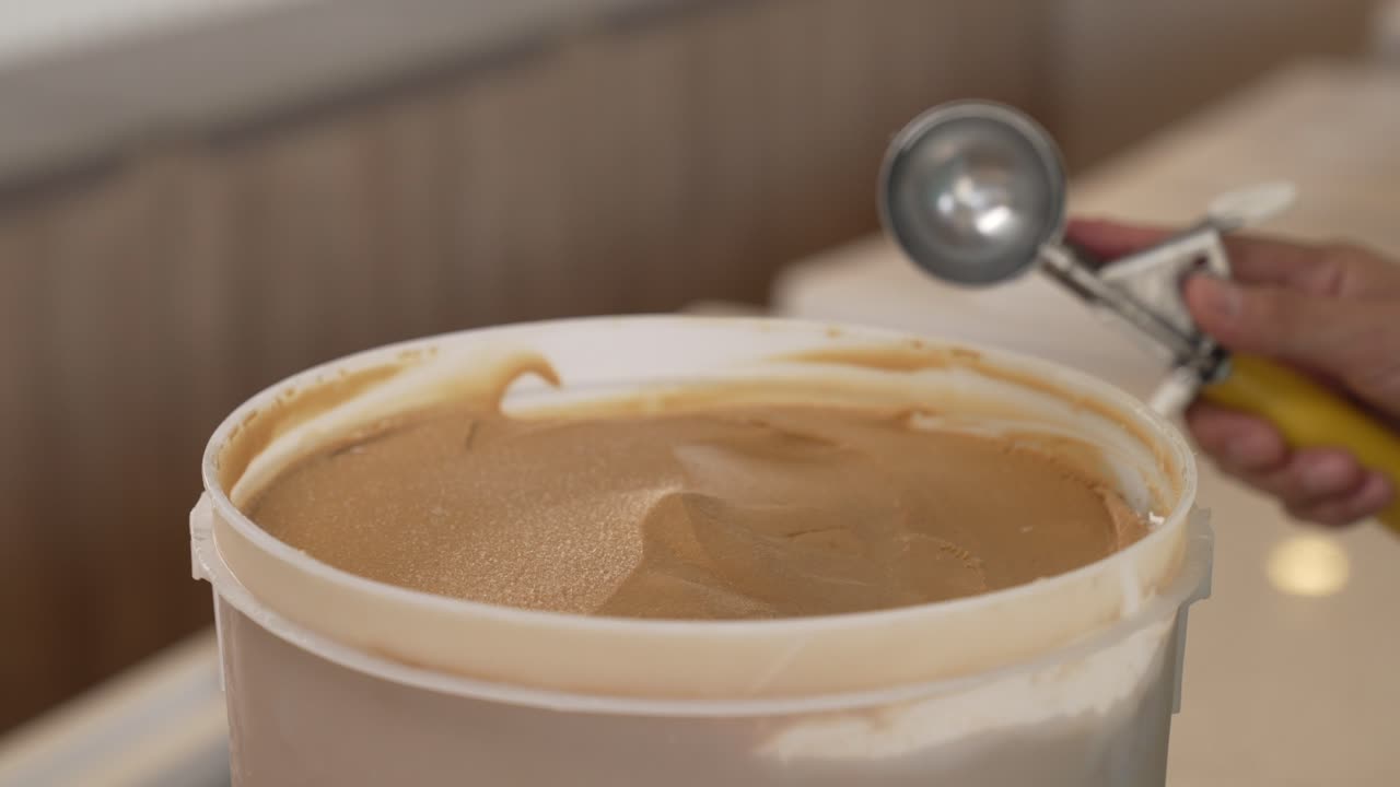 наливая шоколадное мороженое, подчеркивая простое удовольствие от наслаждения классическим и богатым десертом