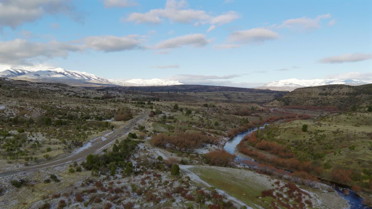 Uma incrível filmagem de drone em uma bela paisagem da Patagônia, montanhas e planícies com rio e estrada sinuosos, Patagônia, Argentina