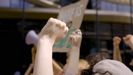 brünette jüdin protestiert neben menschen mit plakaten