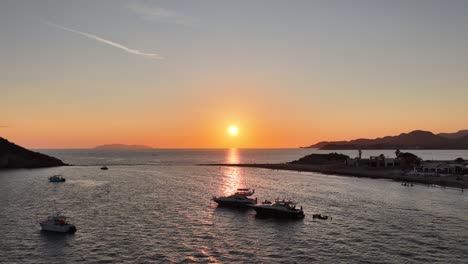 aerial shot of the beach with boats and sunset