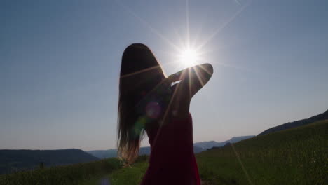 female silhouette is dancing in front of the sun