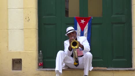 a musician plays a trumpet on the streets of havana cuba