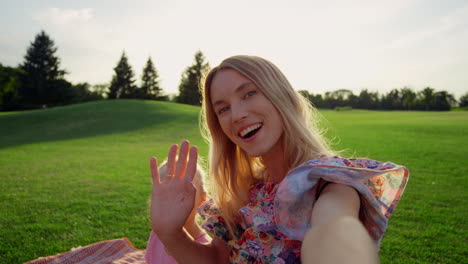 glimlachende vrouw met dochter die een selfie maakt met haar mobiele telefoon op groen gras.