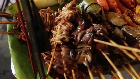 diverse grilled meat in bbq skewers on street food cart at thai night market