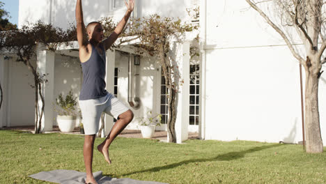 Fokussierter-Biracial-Mann,-Der-Yoga-Im-Sonnigen-Garten-Praktiziert,-Zeitlupe