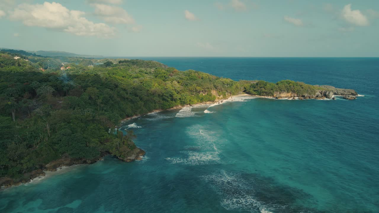 toma de drones de colinas y mar con olas rompiendo en los arrecifes de la costa.