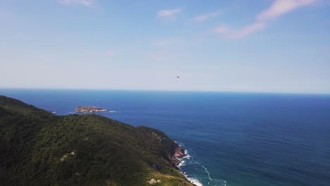 toma aérea de vuelo en paramotor en la playa con cielo azul