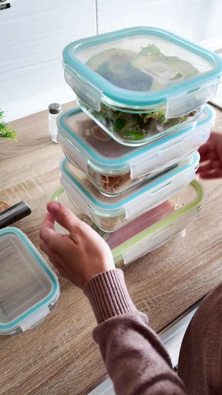 Donna che prepara i contenitori per la preparazione dei pasti settimanali nella cucina di casa