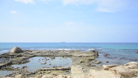 a container ship in the distance in the mediterranean sea off the coast of caesarea in israel