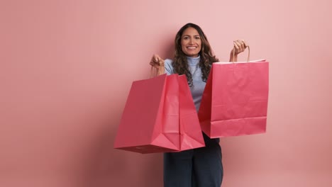 happy hispanic woman showing pink shopping bags