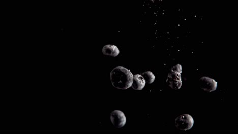 currants falling into water super slowmotion, black background, lots of air bubbles, 4k240fps