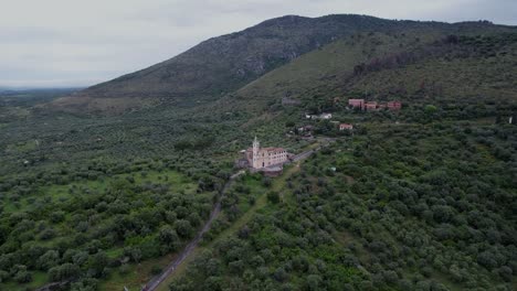Catholic-convent-building-surrounded-by-rolling-green-hills,-Tivoli