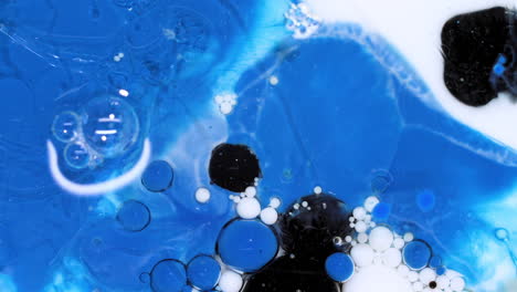 abstract art background of bursting blue and black colors, ink bubbles reacting