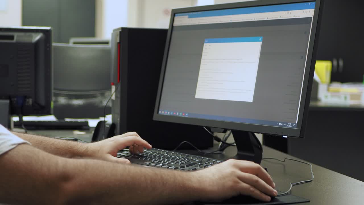 plano medio de vista lateral de ingenieros experimentados mirando la pantalla de la computadora y escribiendo en el teclado