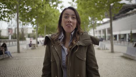 cheerful beautiful woman talking to camera during stroll.