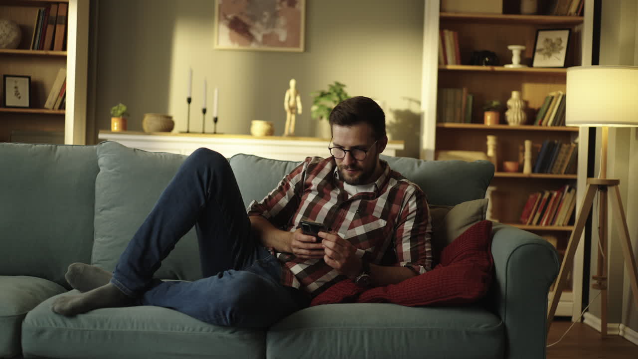 Man relaxing on couch with phone
