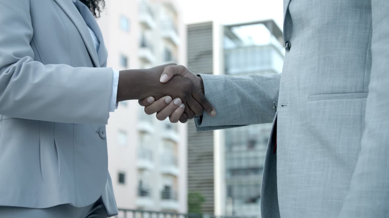 Cropped shot of African American colleagues meeting on street