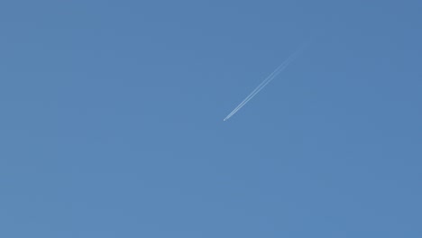 aeroplane in sky with contrail vapor trails clear blue sky australia, victoria, gippsland, maffra daytime wide shot