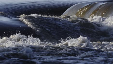 primer plano de un río con olas y salpicaduras dinámicas de agua, capturando el poderoso movimiento del agua