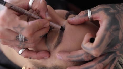 crop man drawing eyebrow to woman