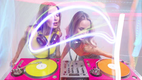 djs gemelas idénticas bailando detrás de tocadiscos y luces de discoteca