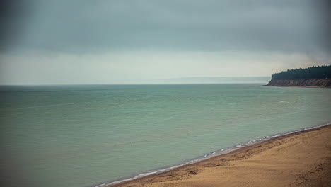 Timelapse-Mirando-Hacia-La-Costa-De-La-Playa-Con-Nubes-Formándose-En-Una-Neblina-De-Lluvia-En-El-Horizonte