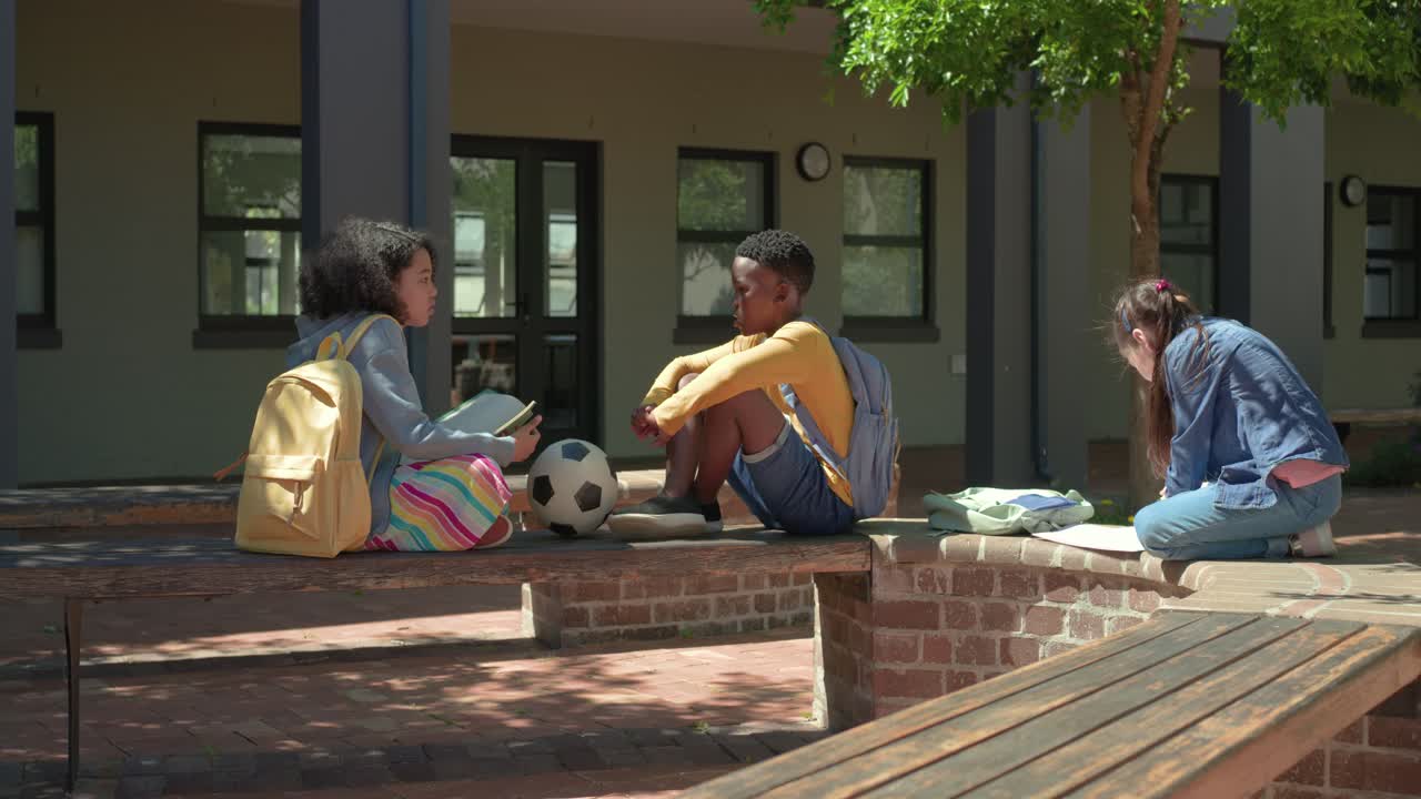 Verschiedene Teenager in der Schule zeigen Notizen, planen ein Spiel mit einem Fußball, ein Junge hört zu, ein Mädchen schreibt