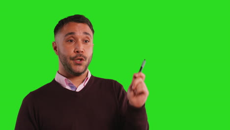 Close-Up-Studio-Portrait-Of-Mature-Male-Teacher-Talking-To-Class-Standing-Against-Green-Screen-Background-2