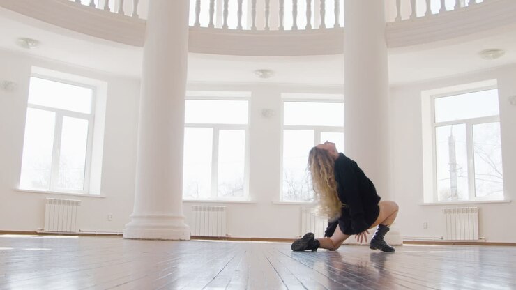 Focused Blonde Woman In Black Long Sleeve Loose Pullover And Boots Performing A Contemporary Dance In The Studio 1