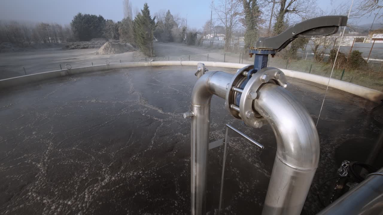 Dynamic traveling shot of an industrial tank with pipes, symbolizing industrial progress and efficiency, dominated by metallic tones.