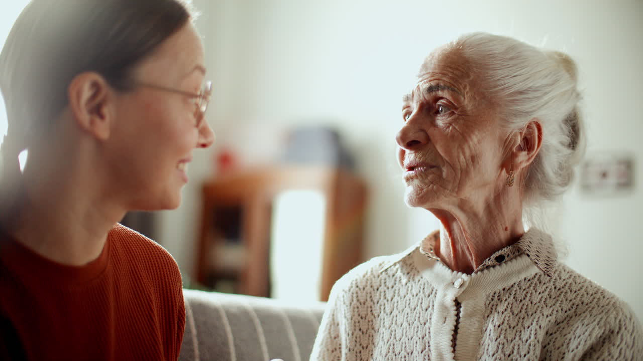 Elderly Woman Having Enjoying Conversation with Granddaughter at Home