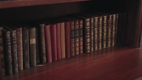 row of vintage books on a wooden bookshelf