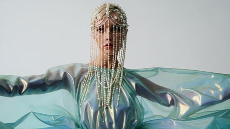 a captivating fashion display featuring ethereal accompaniments of pearls and iridescent textiles showcasing unique design and artistic expression