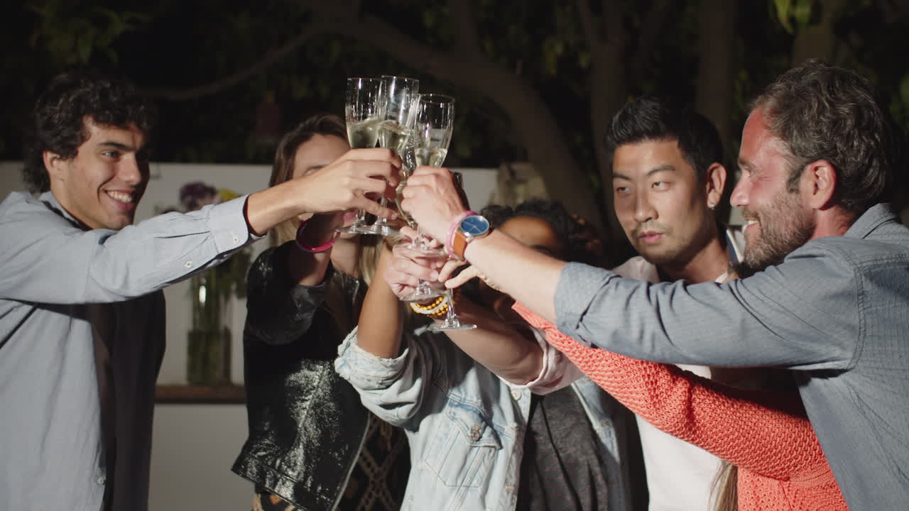 Medium shot of happy friends clinking glasses of champagne