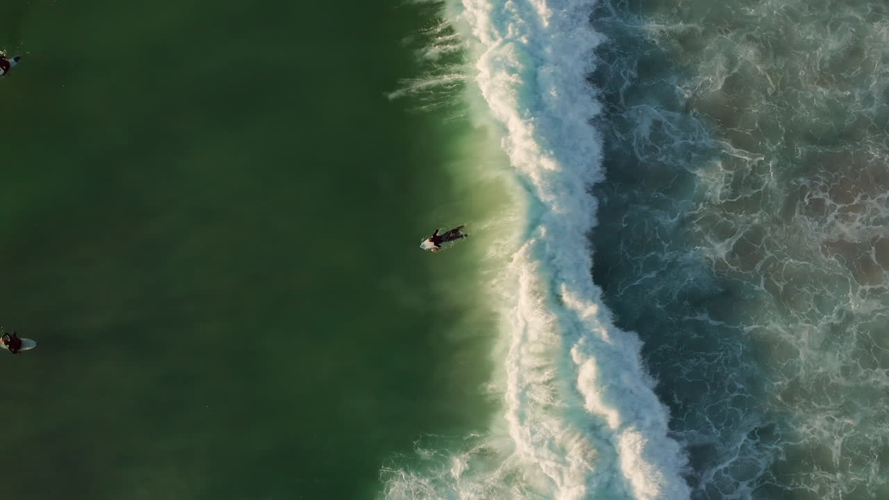 surfistas en la ola en la playa de llandudno, ciudad del cabo, sudáfrica - vista aérea de arriba hacia abajo