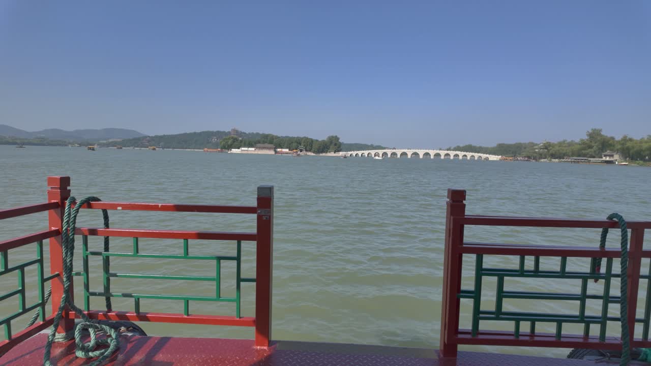 Video 4K di una barca che si avvicina al ponte a diciassette arcate sul lago Kunming, vicino al Palazzo d'Estate a Pechino, in Cina