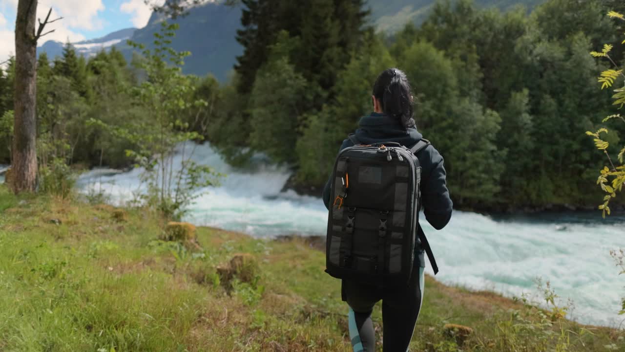 una mujer de senderismo camina con una mochila de senderismo en la hermosa naturaleza de noruega.