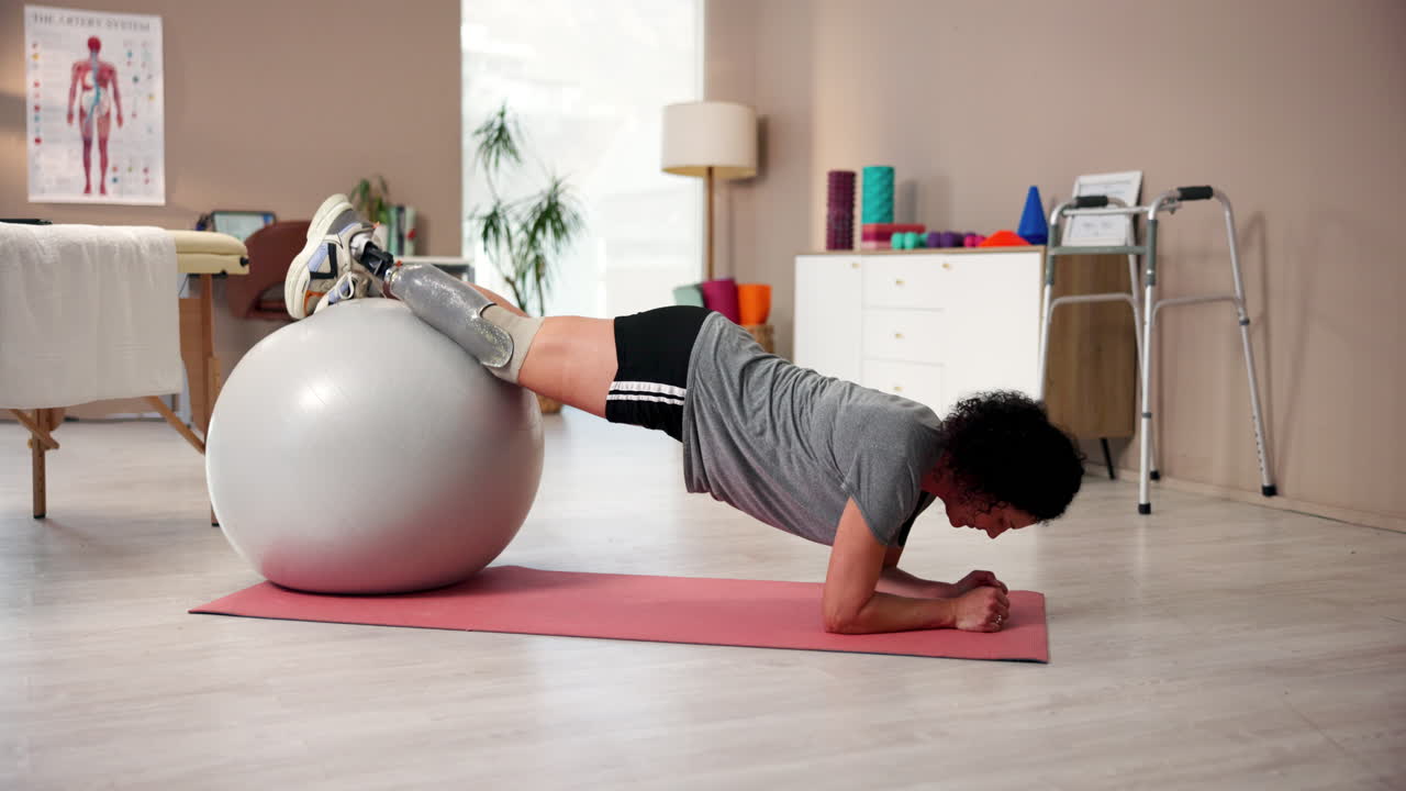 Woman with prosthetic leg doing exercise on a fitness ball