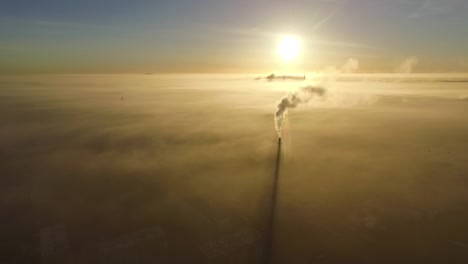 Dense-fog-over-city-Valmiera-in-early-winter-morning-sunlight-aerial-footage-wide-shot