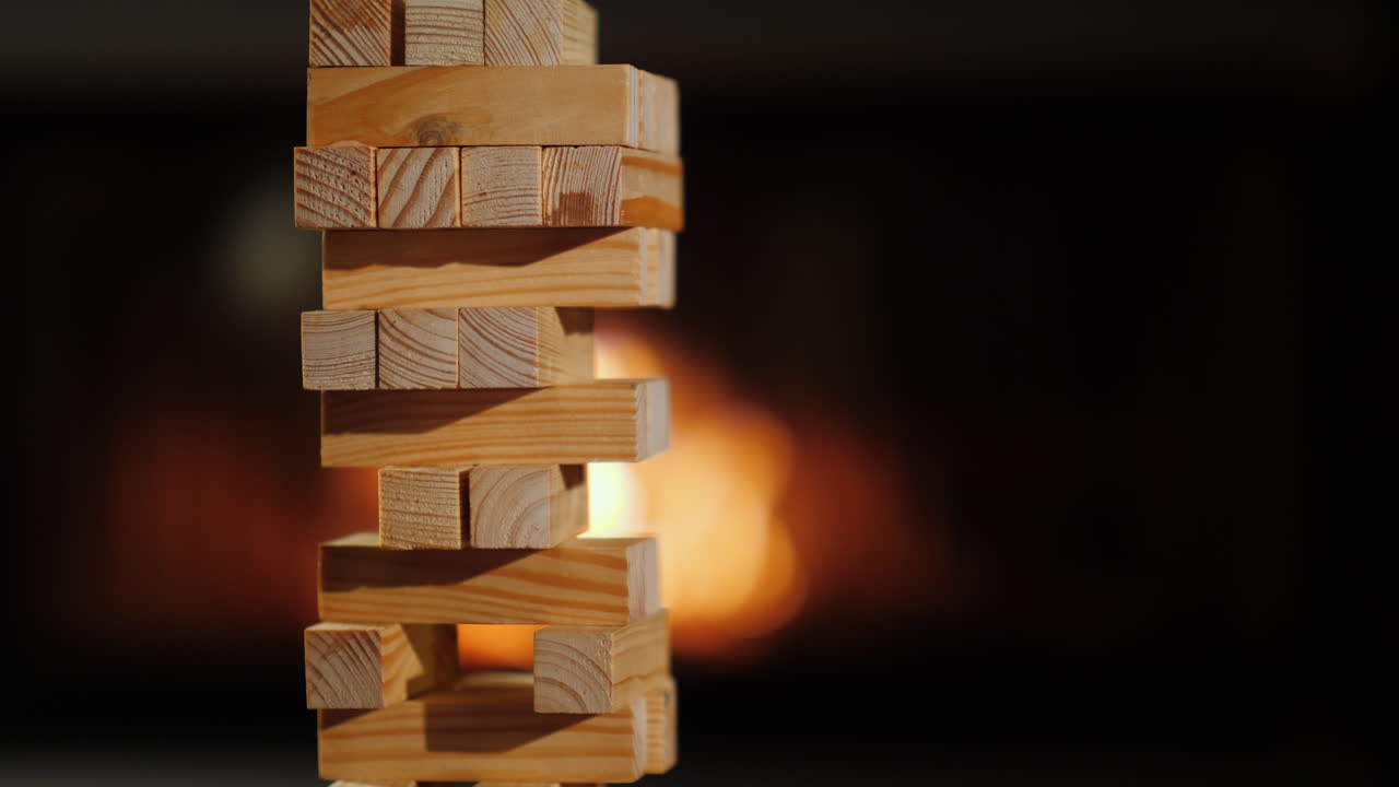 una mano saca un bloque de madera de los juegos de mesa de la torre y el concepto de velada juntos