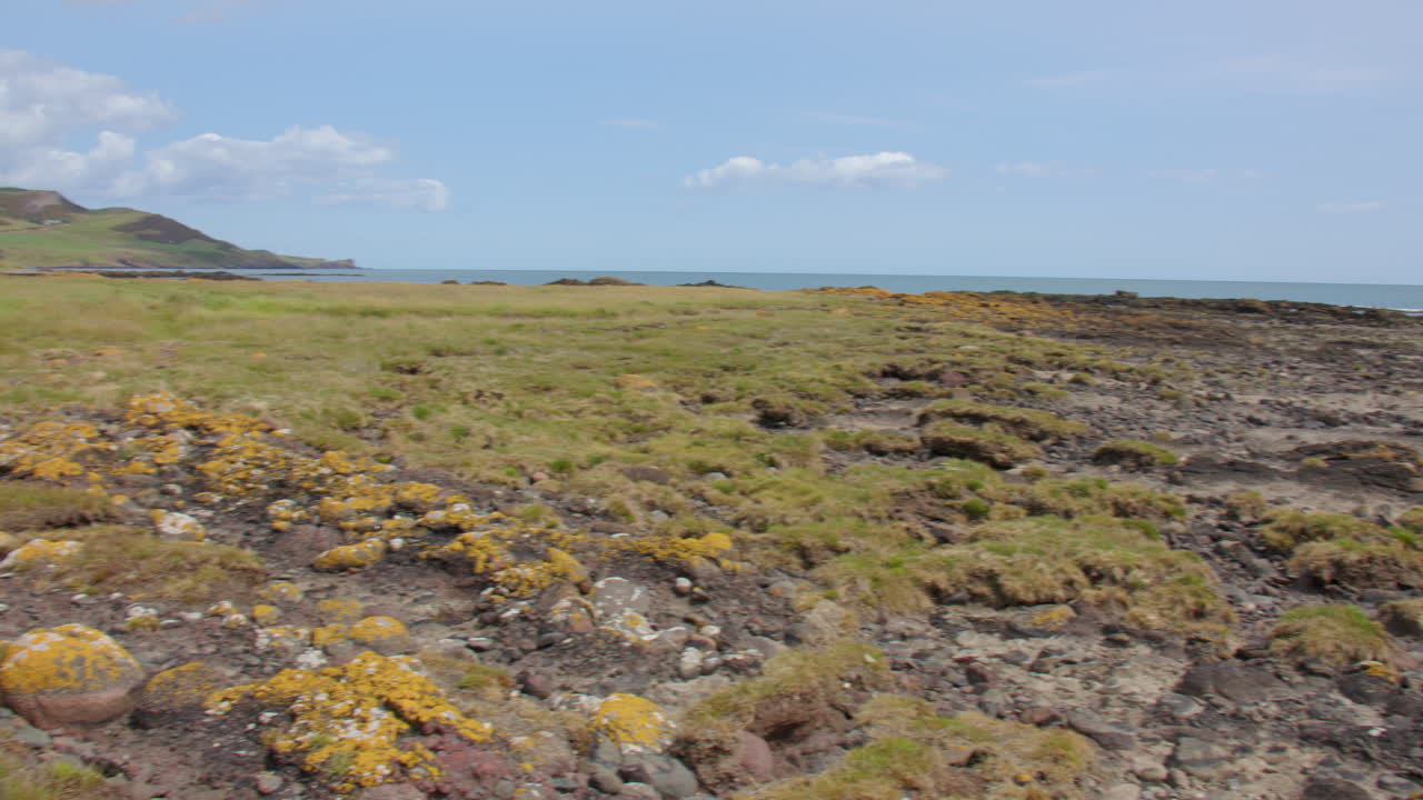 Panning Wide shot looking of the exposed rocks and beach at low tide at Gourdon