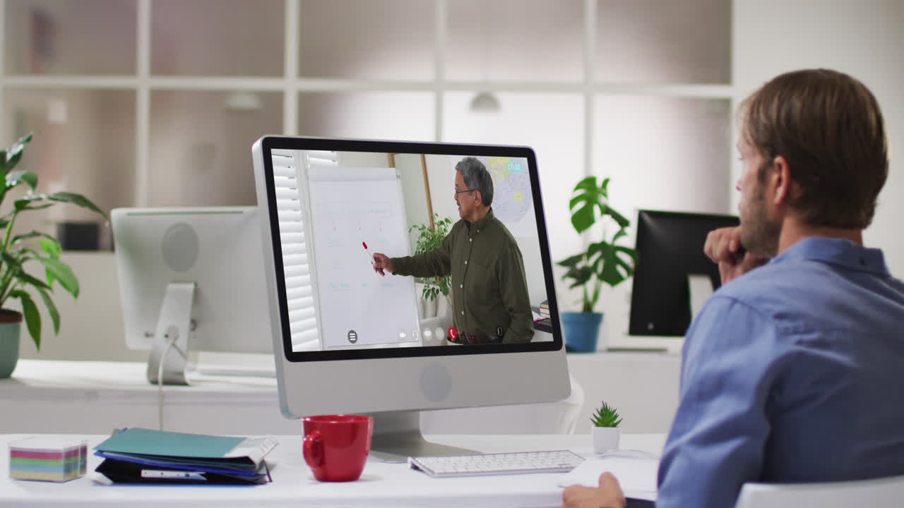 Caucasian male student using computer on video call with male teacher