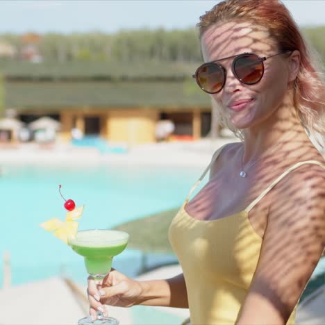 Stylish-woman-with-green-beverage-on-hotel-terrace