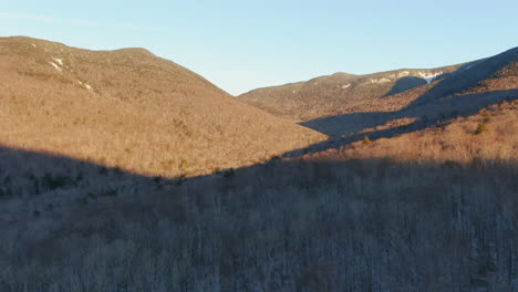 Aerial-cinematic-pan-right-motion-sunrise-first-light-of-mountain-landscape-and-forest-at-Loon-Mountain-Resort-New-Hampshire