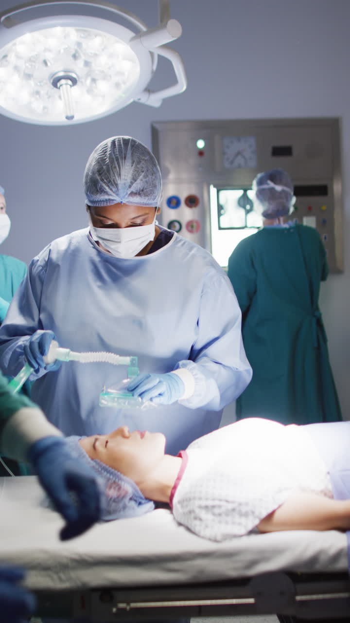 Vertical video of diverse surgeons with face masks during surgery