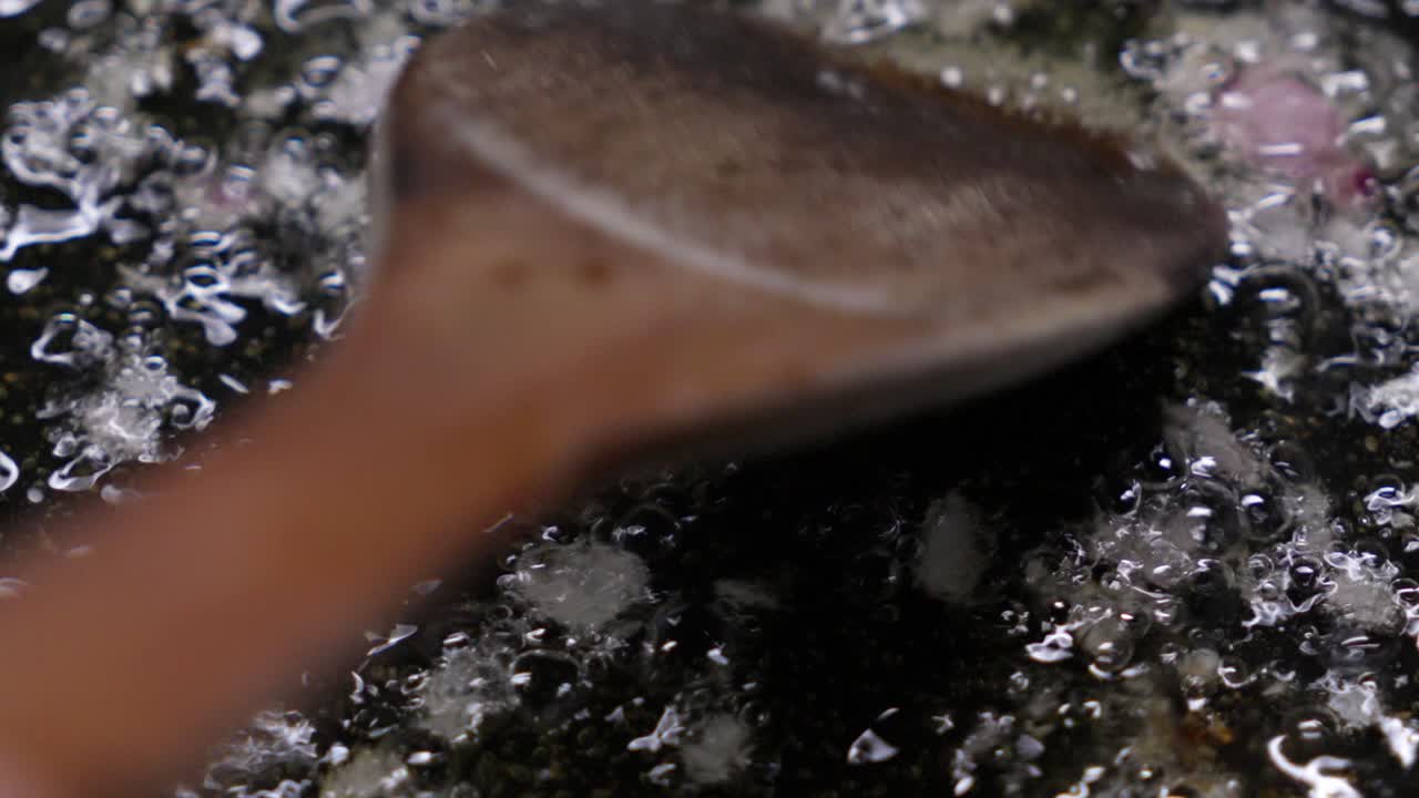Frittura di scalogno in olio bollente con bolle in padella, scena di cucina in primo piano