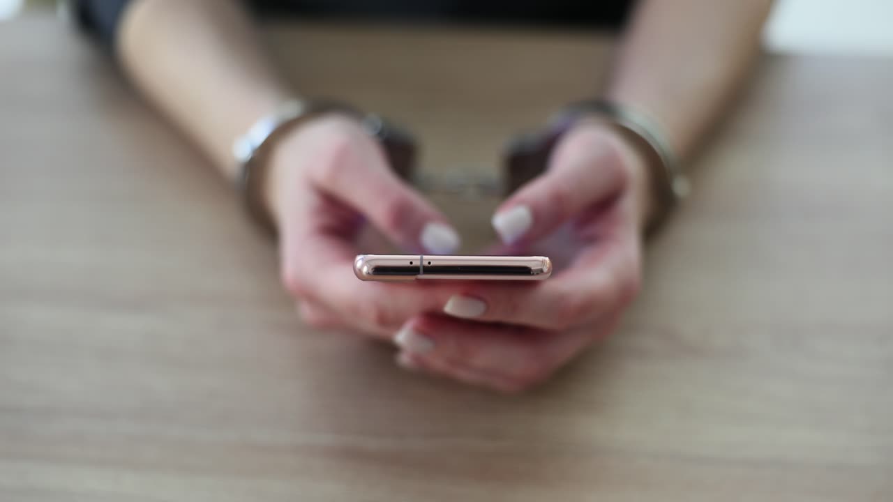 Hands in Handcuffs Holding a Smartphone